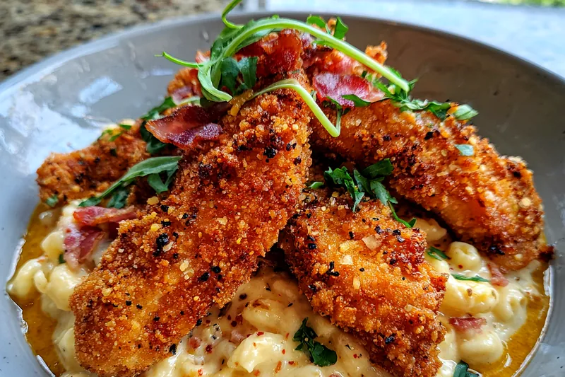 A vibrant display of fresh ingredients for Honey Pepper Chicken Mac & Cheese, including chicken, cheese, and pasta.