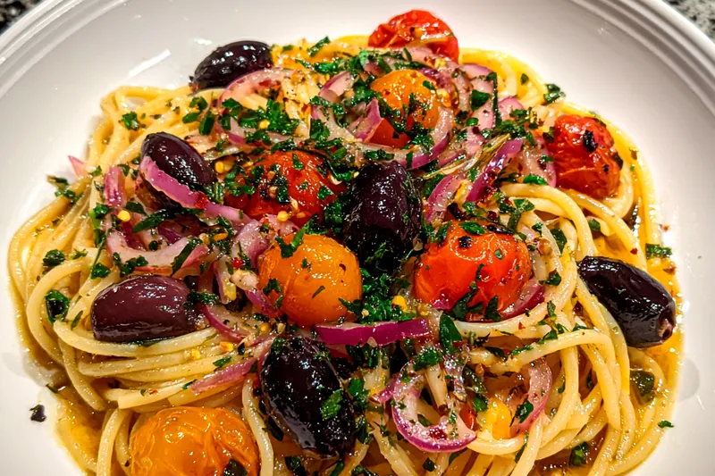 Fresh ingredients arranged for Quick Vegan Mediterranean Pasta including pasta, vegetables, and spices.
